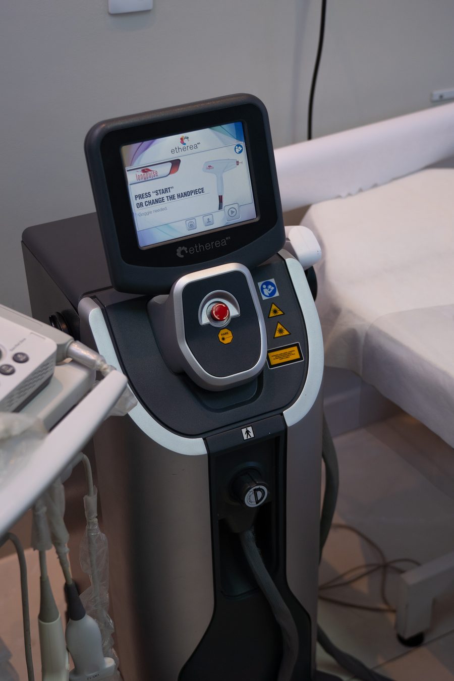 Equipamento de laser ao lado da maca de atendimento